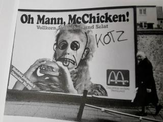 Foto eines McDonalds Werbeplakats, mit Graffito geändert zu einem angeekelten Gesicht und dem Wort 